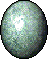 An oval, speckled jade-green egg. It is more speckled towards it's bottom than it's top.